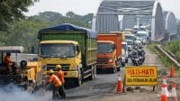 Pekerja mengaspal ulang Jembatan Sungai Pemali di Jalingkut Brebes, antrean kendaraan mencapai 1 km